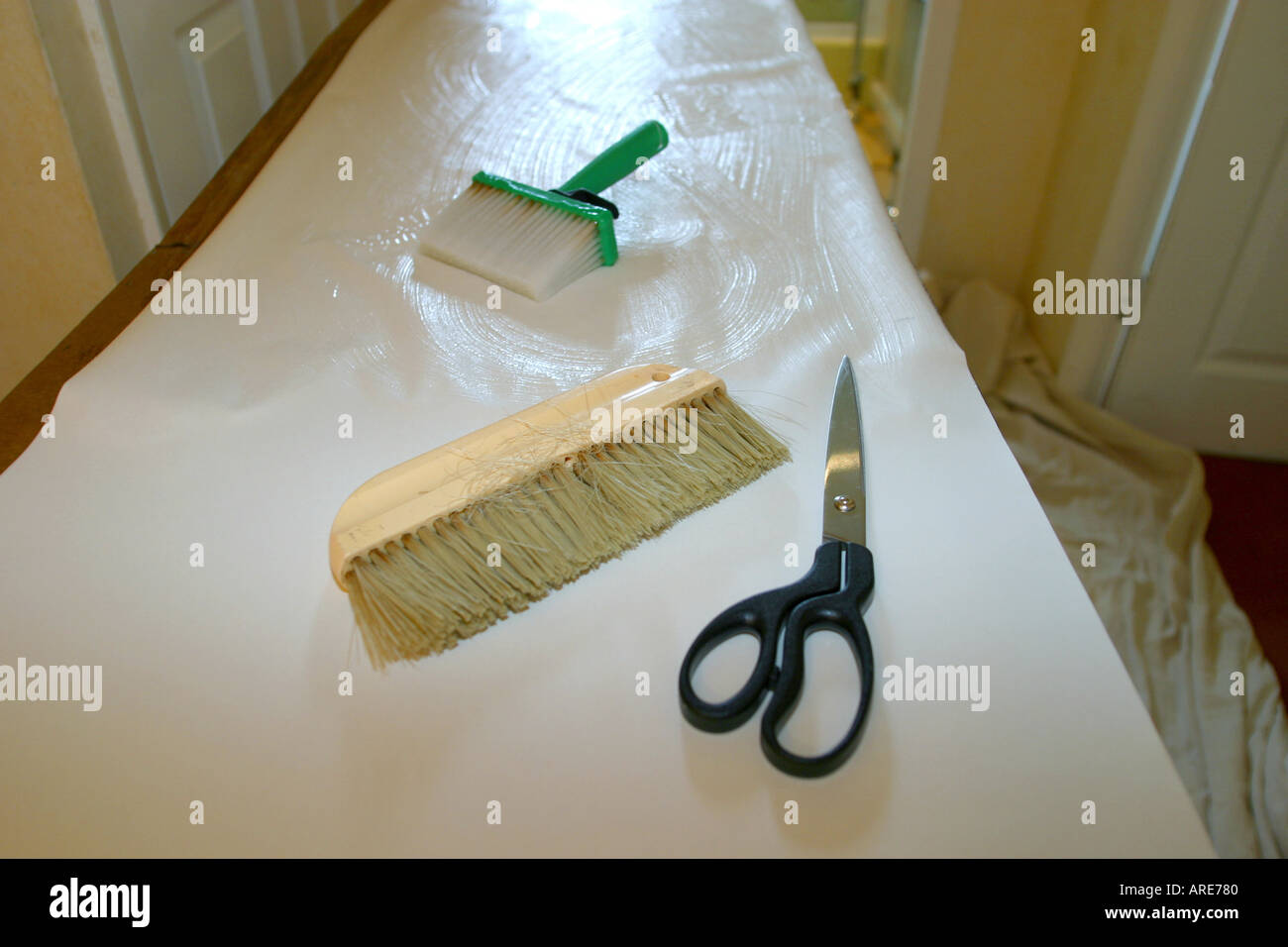 Paperhanging tools on pasted wallpaper on pasting table Stock Photo