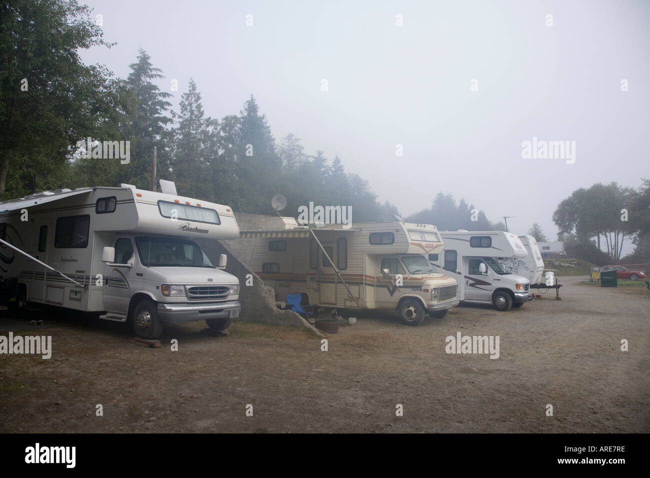 Motor homes and caravans in coastal sea fog on campsite Ucluelet Vancouver island Canada Stock Photo