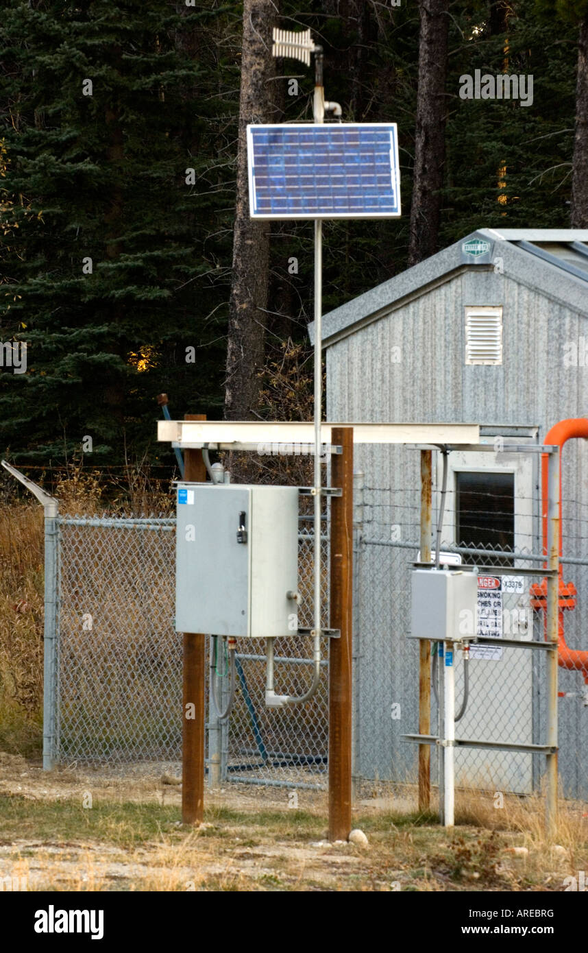 A vertical image of a solar power panel supplying electricity to a power box at a remote natural gas monitor site Stock Photo