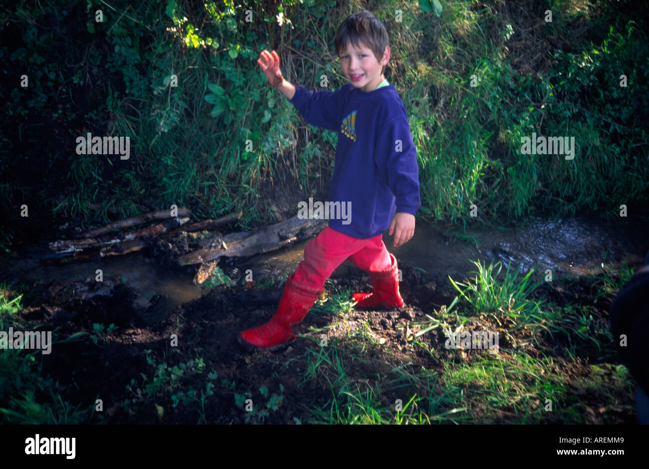 Young boy wearing red wellington boots 