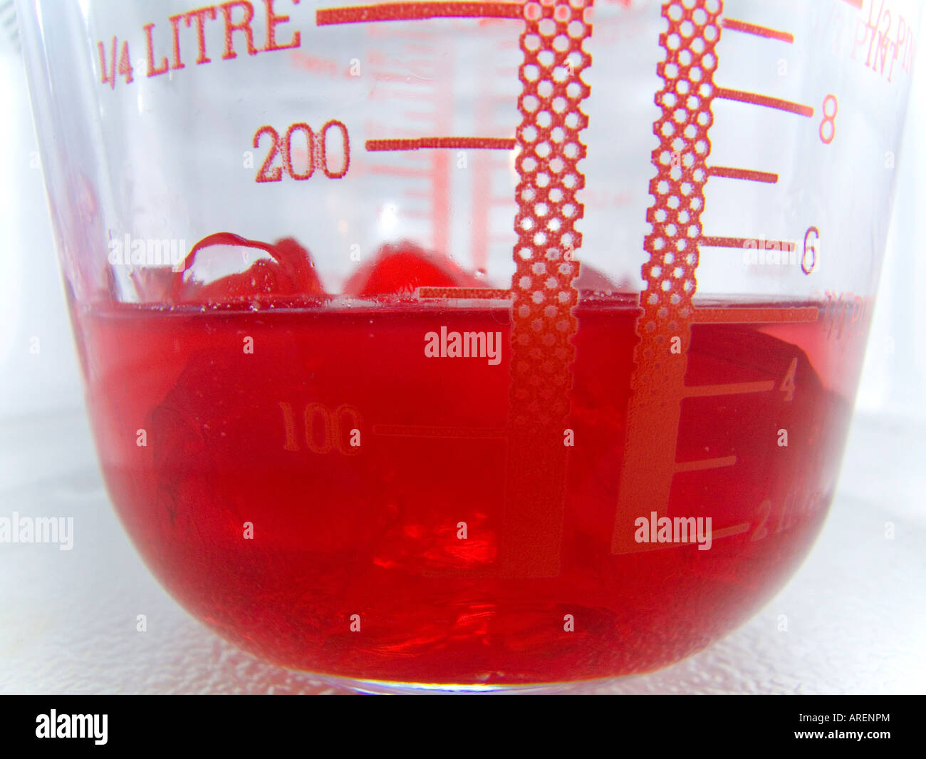 A block of red jelly dissolving Stock Photo