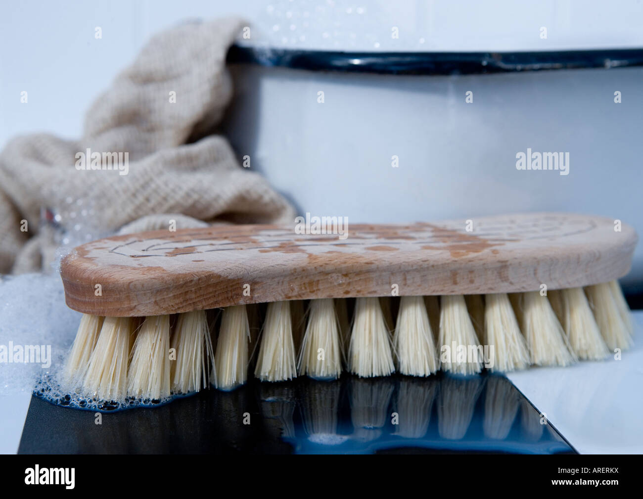 Dirty cast iron skillet being prepared for cleaning with coarse salt, brush,  scraper and dish towel on a counter Stock Photo - Alamy
