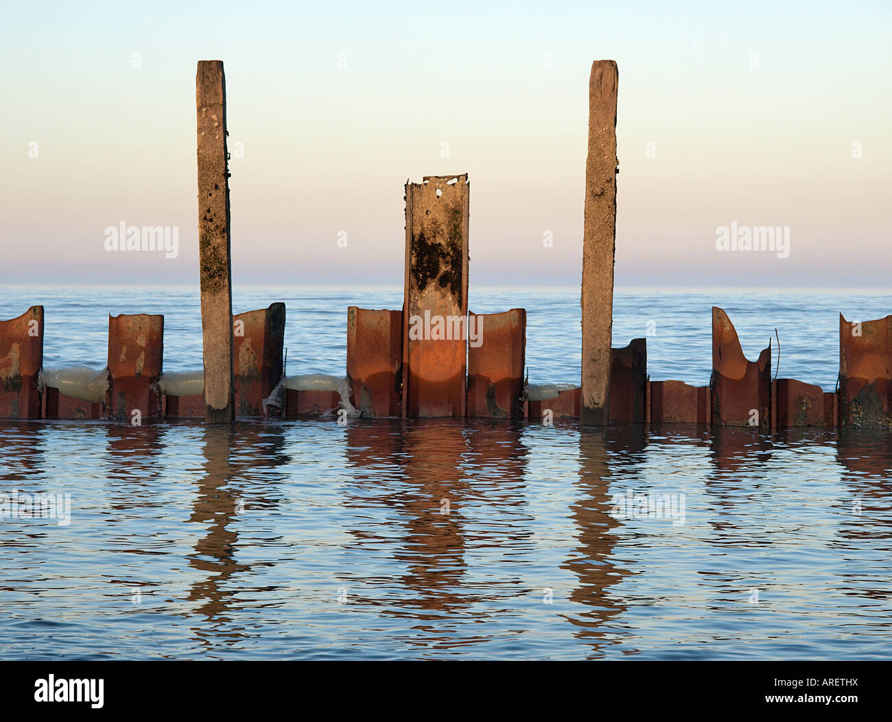 LOW TIDE ON HAPPISBURGH BEACH WITH BROKEN SEA DEFENCES REFLECTED IN ...
