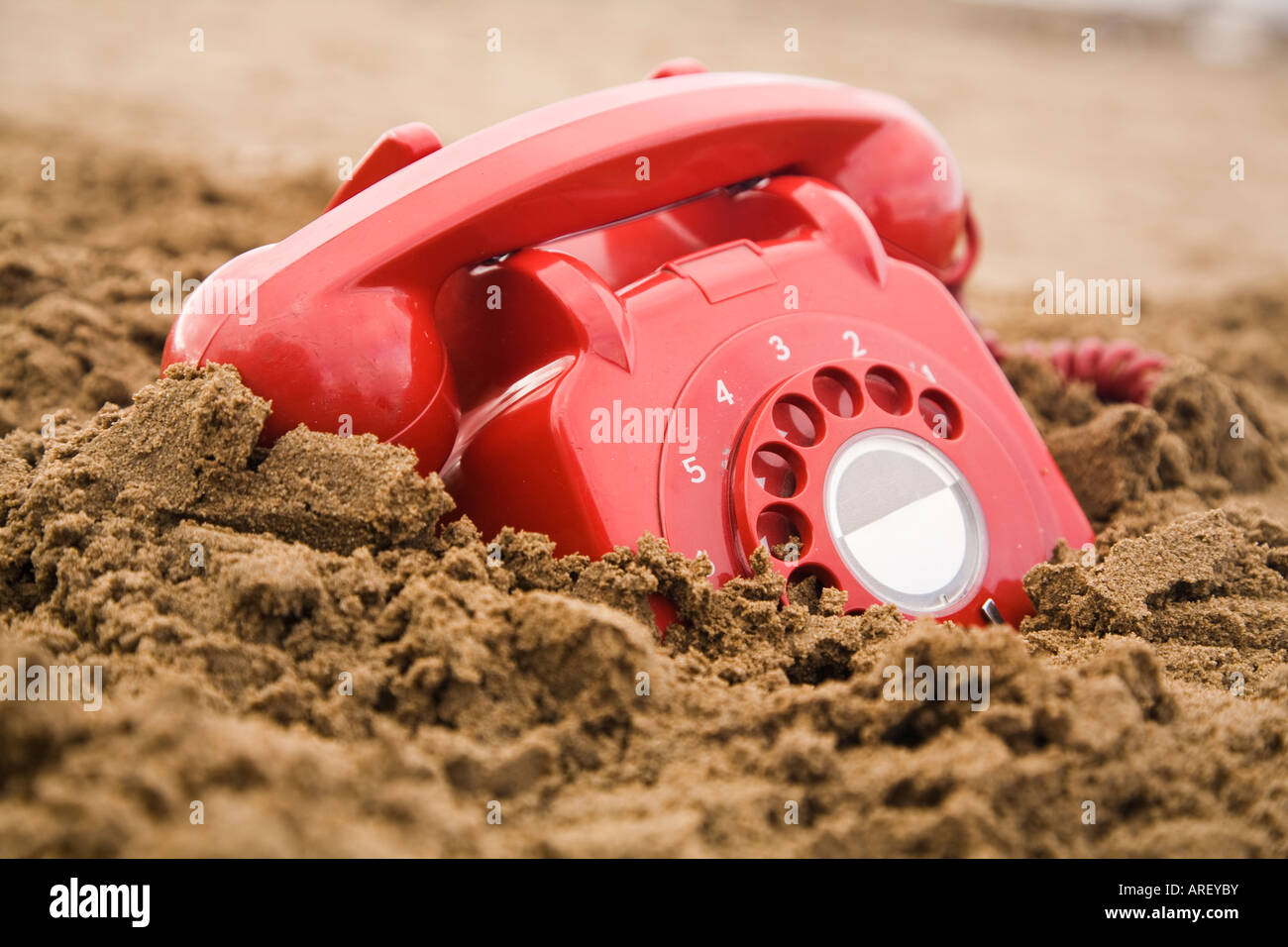 Old retro uk phone buried in the sand on a beach Stock Photo - Alamy
