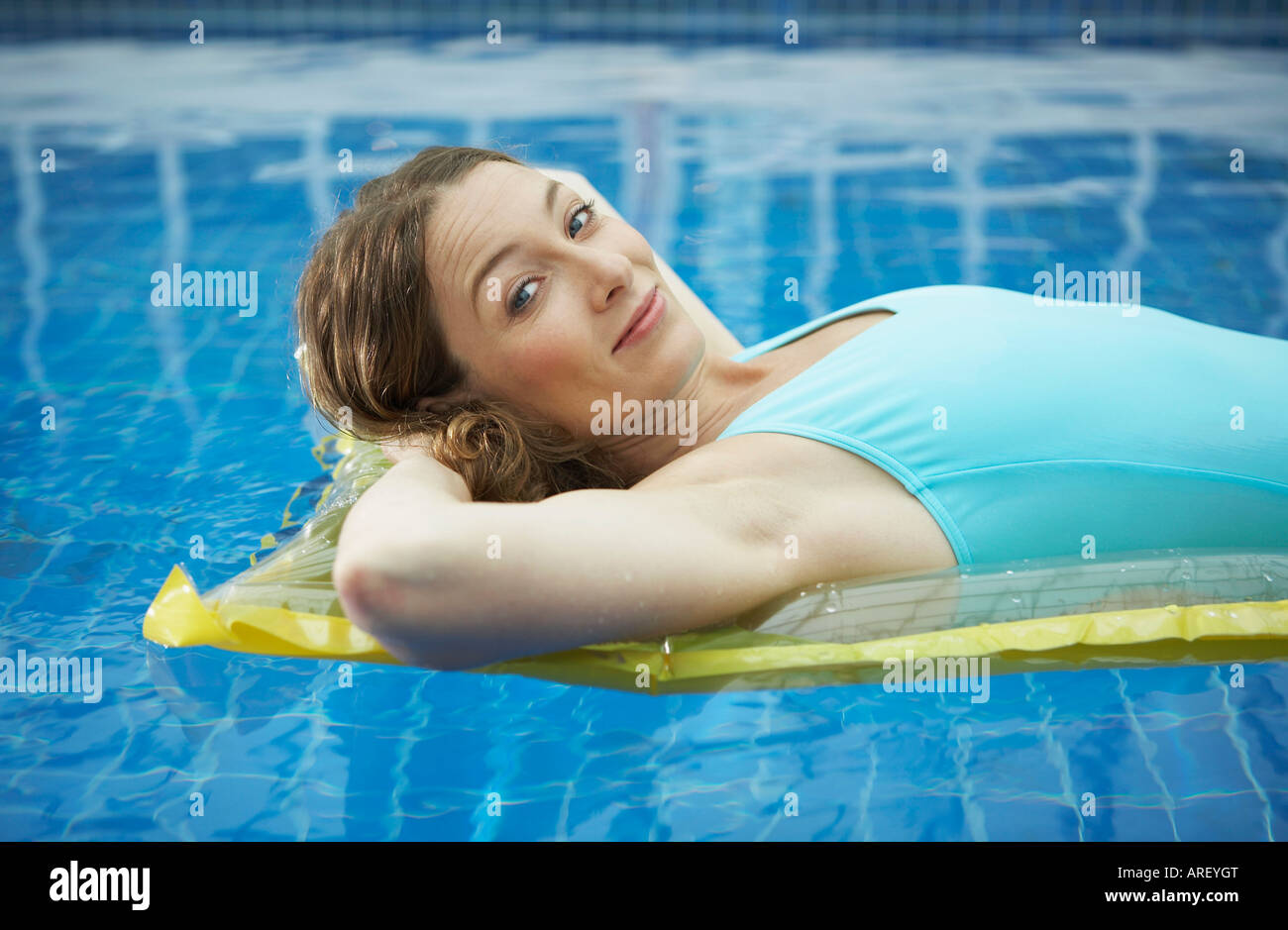 Portrait of woman lying on a lylo Stock Photo