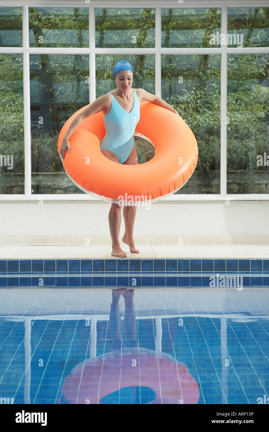 Woman standing with rubber ring by pool Stock Photo