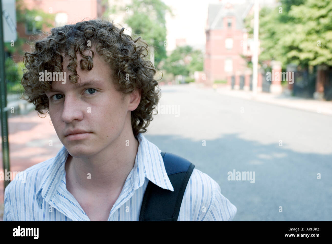 Young man standing outdoors with backpack Stock Photo