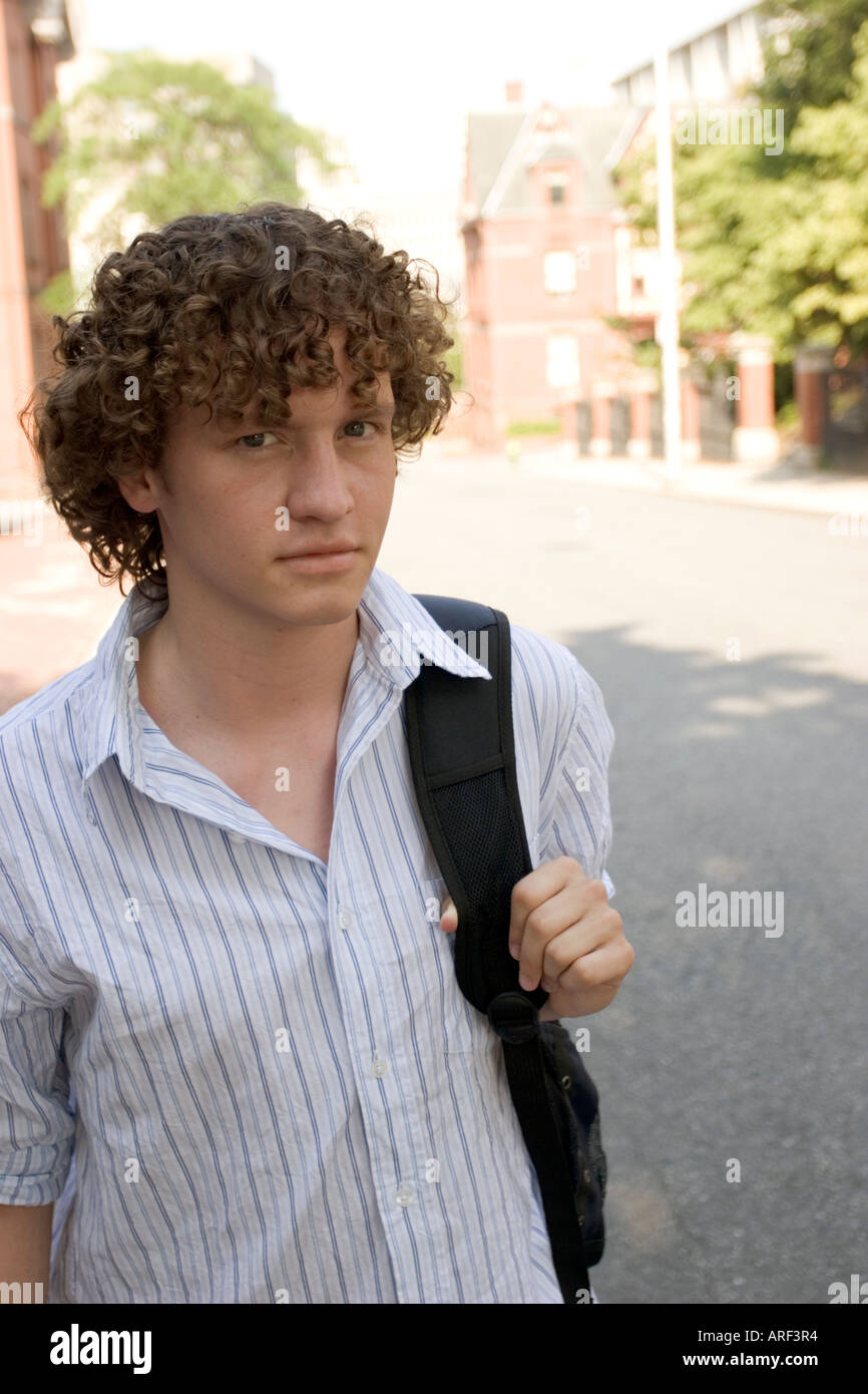 Young man standing outdoors with backpack on shoulder Stock Photo