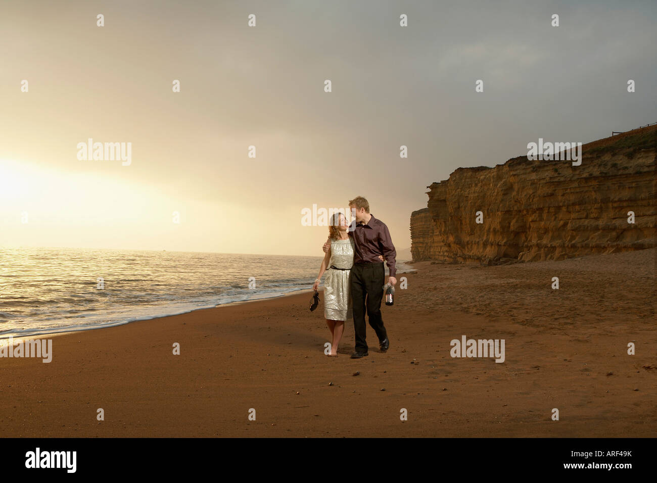 Man and woman strolling along a beach Stock Photo