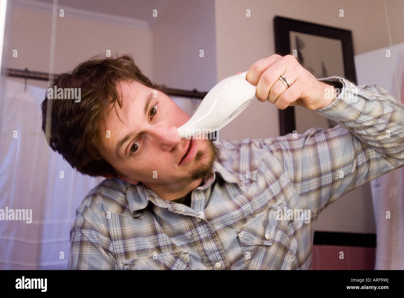 Neti Pot user to help clear sinuses Stock Photo