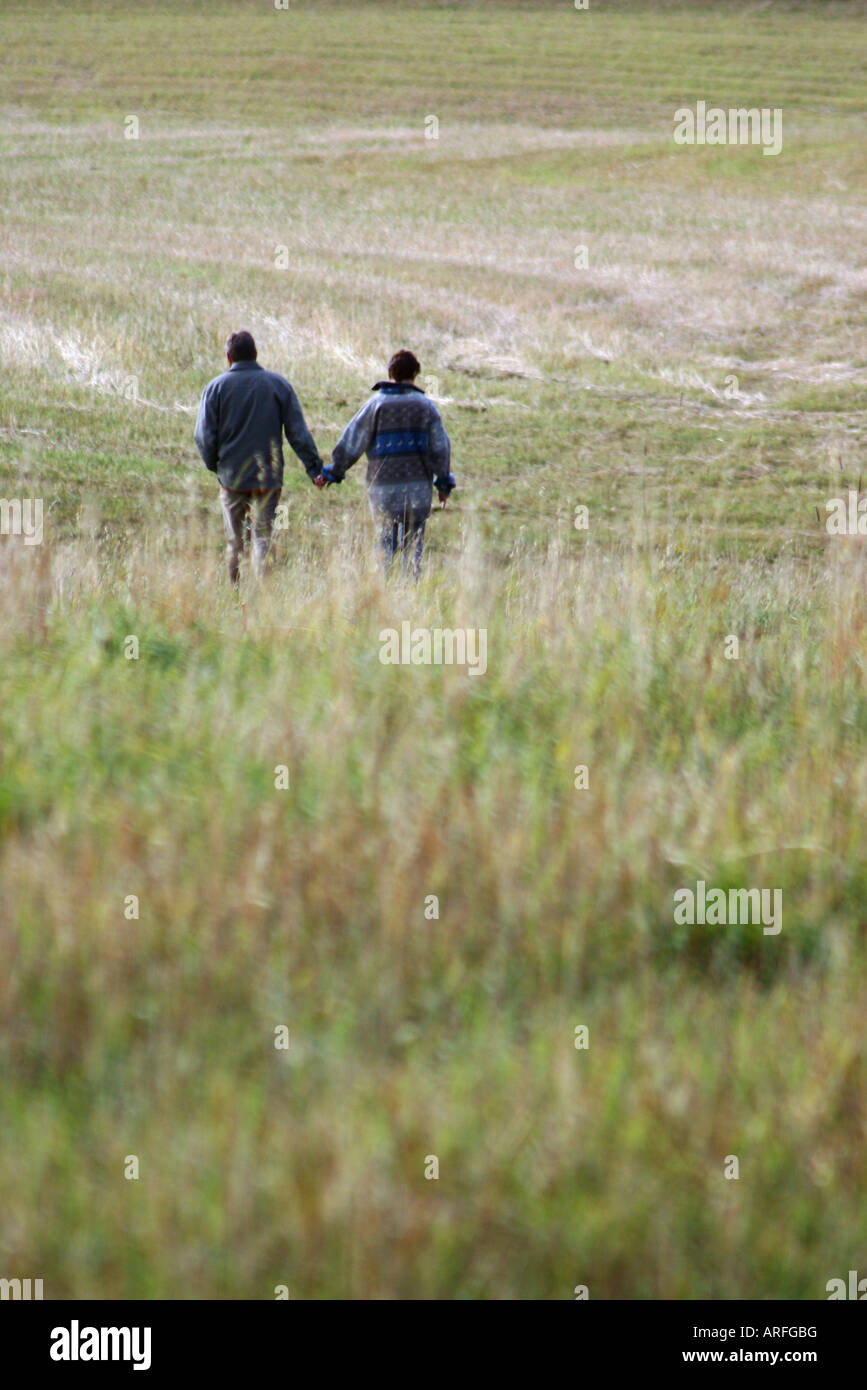 A couple walks hand in hand Stock Photo - Alamy