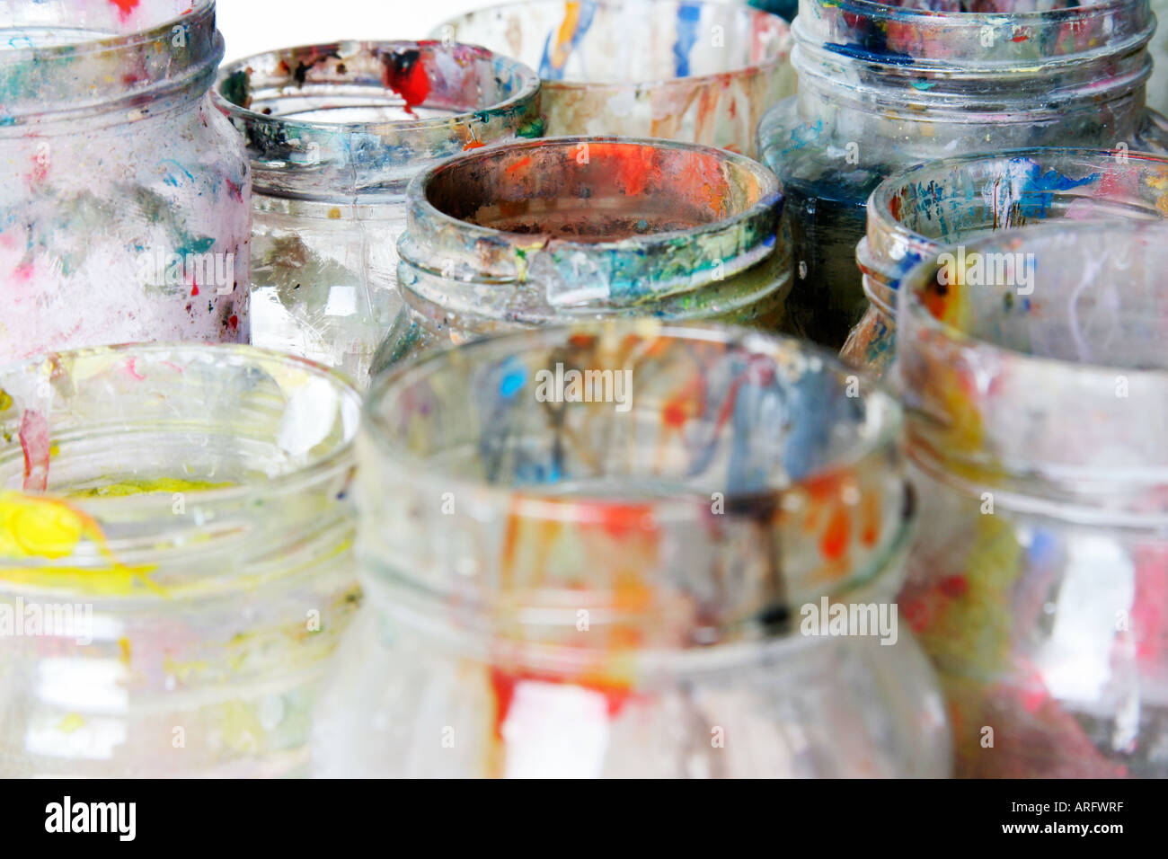 Glass jars used in an art classroom for washing paint brushes Stock