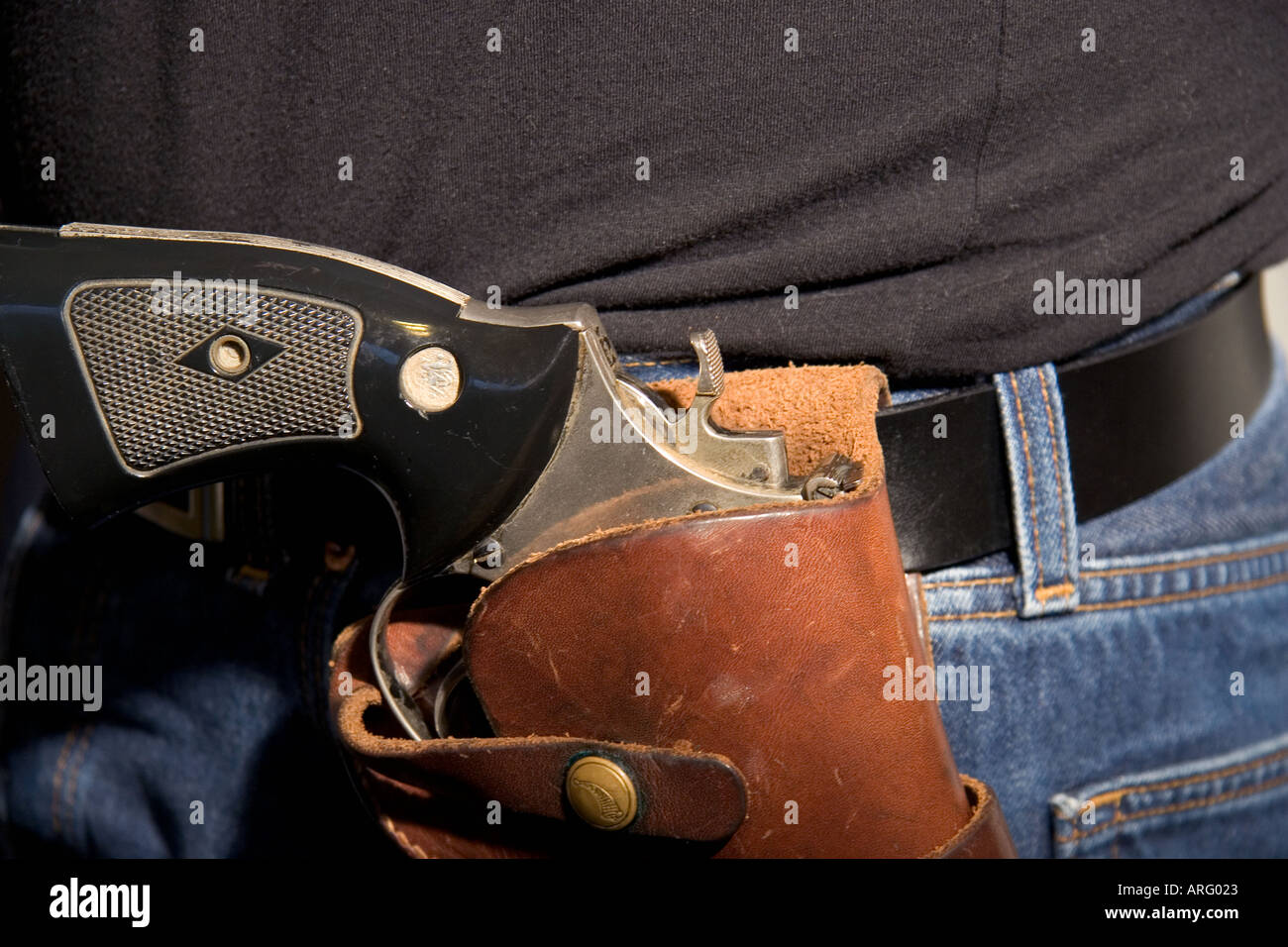 44 Magnum gun in holster on waist of person wearing jeans and a black t ...