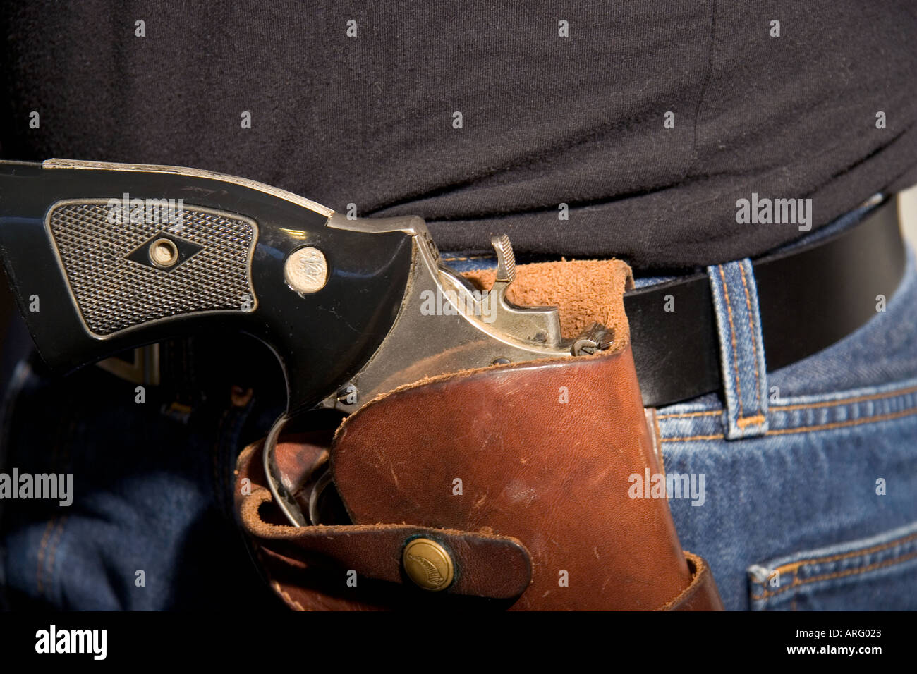 44 Magnum gun in holster on waist of person wearing jeans and a black t
