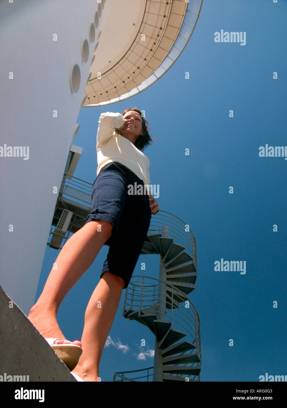 A Low Angle Shot Of Young Woman Standing In Front Of High Modern