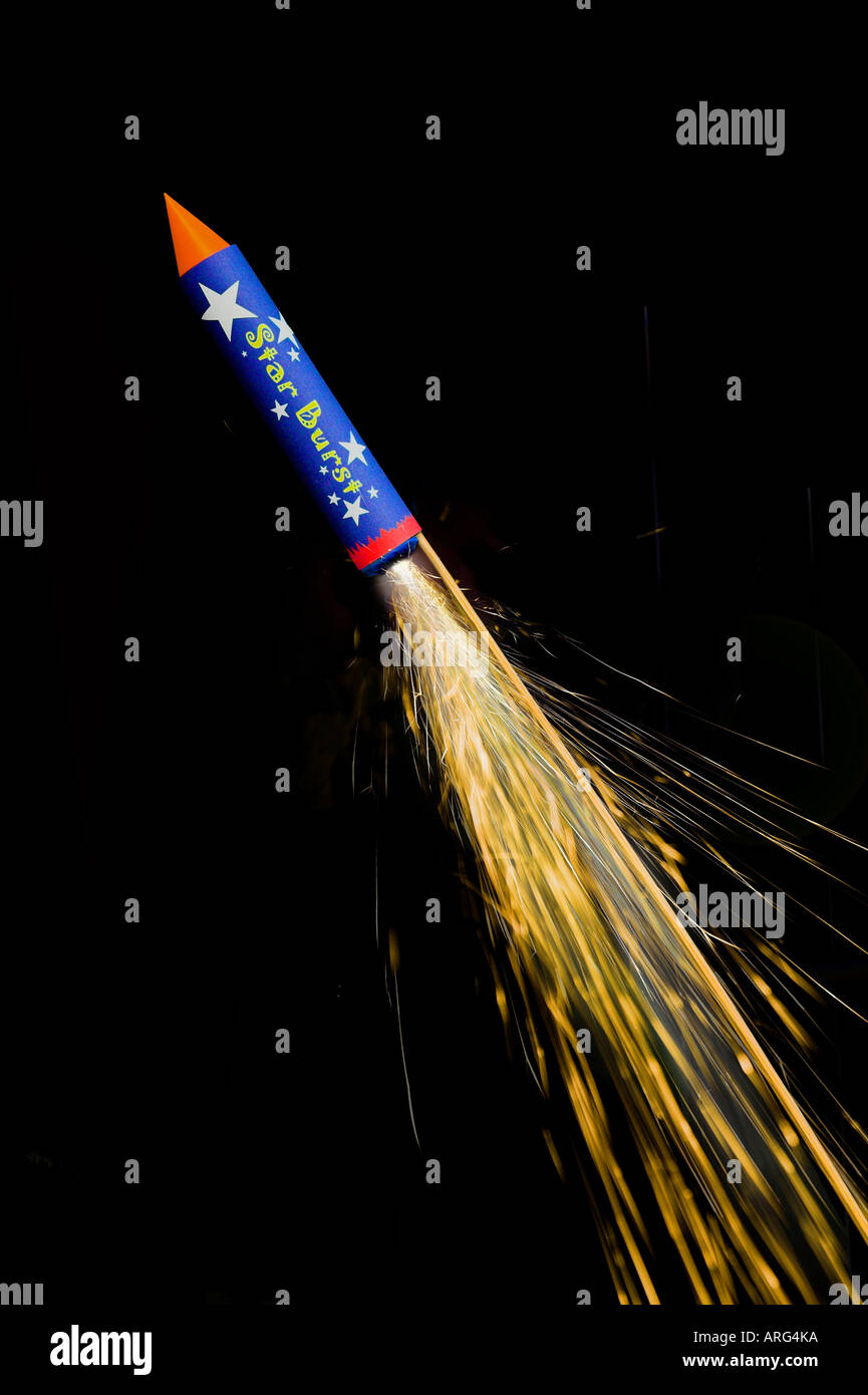A firework rocket with trail of sparks captured against black Stock Photo