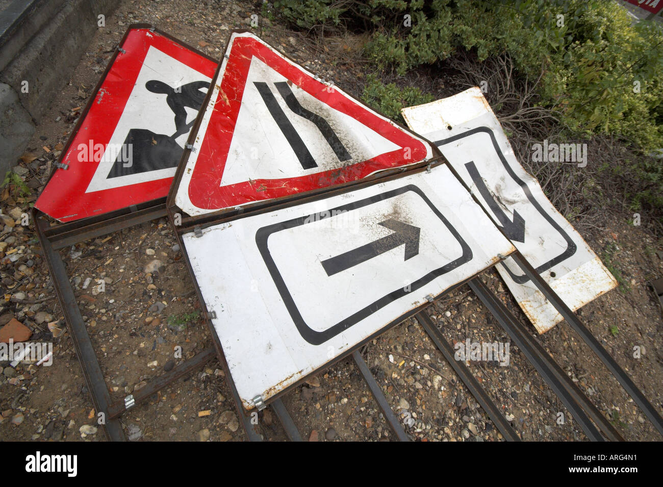 Well-used road repair signs lay discarded Stock Photo