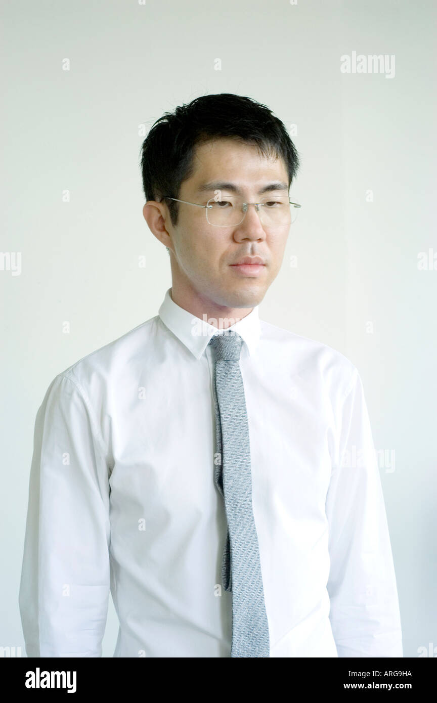 Portrait young Asian Businessman in Medium Shot "Looking Down" off Camera Dressed in "White Shirt and Tie" "White Background" Stock Photo
