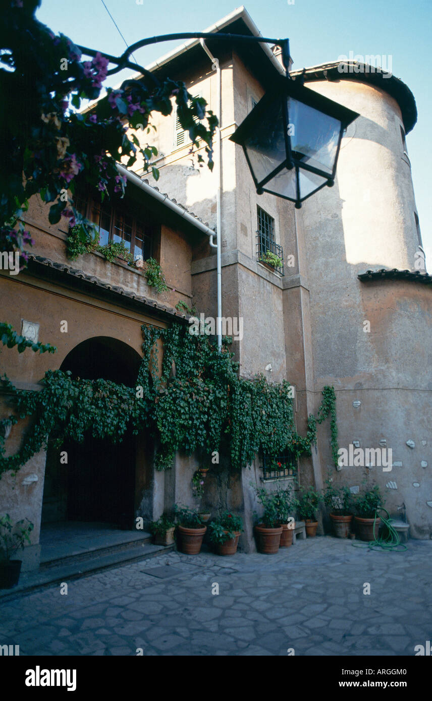 Plants in pots and ivy line the walls at the entrance to the Catacomb di Priscilla among Rome s oldest catacombs Stock Photo