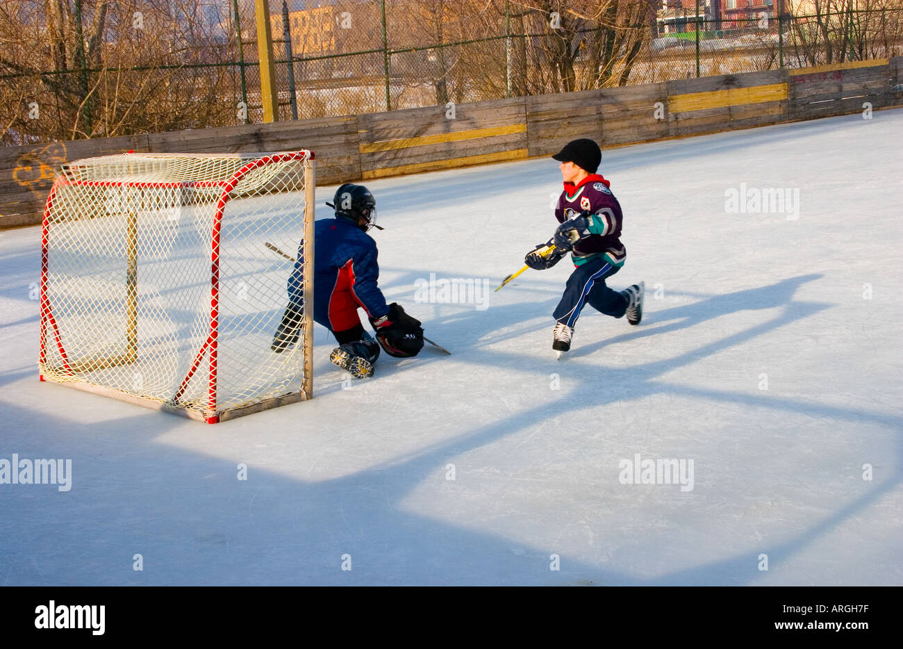 Young boys playing ice hockey outdoors Stock Photo Alamy
