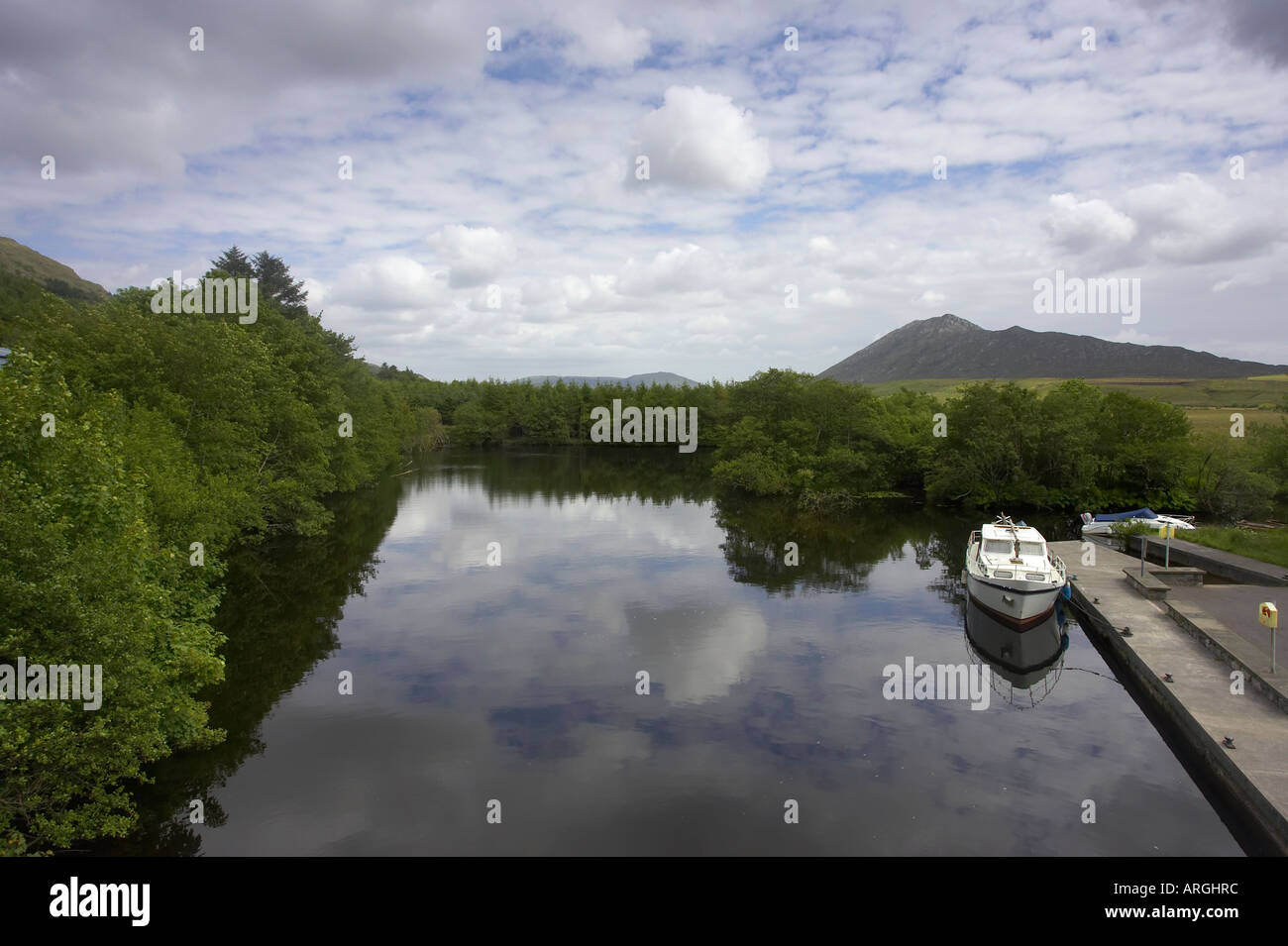 cruising boat moored at jetty on river and maam valley maam cross connemara County Galway Republic of Ireland Stock Photo