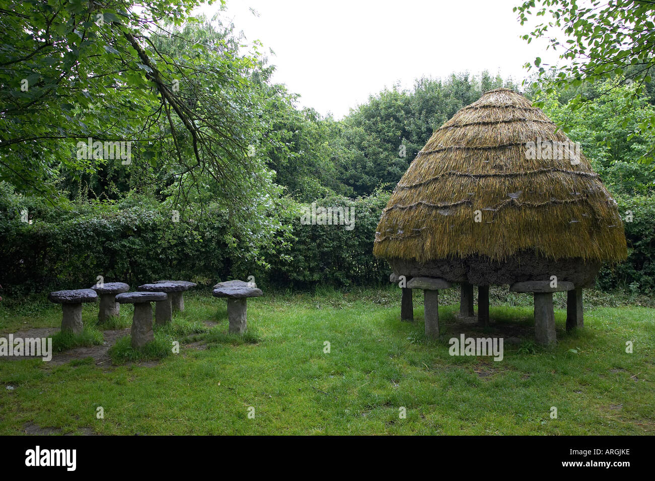 Traditional hay stack on ancient toadstool stands and empty stands Bunratty Folk Park County Clare Republic of Ireland Stock Photo