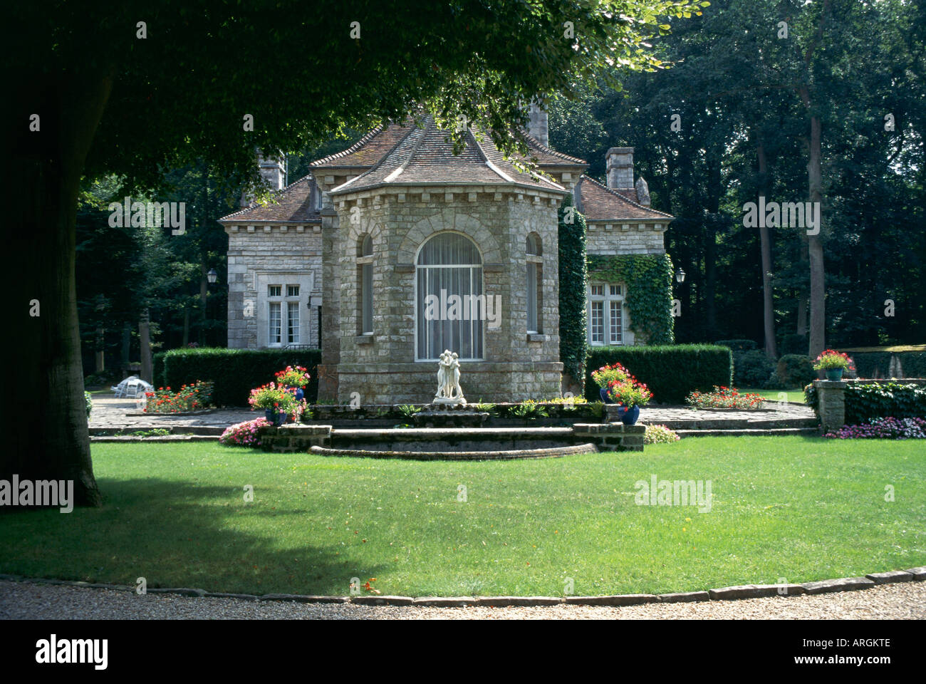 Set beneath tall trees amidst formal gardens a pavilion at the entrance ...