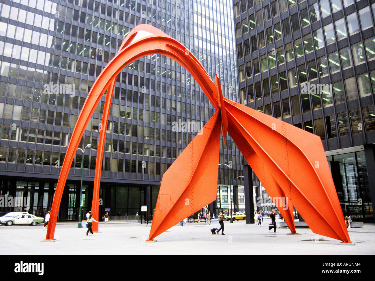 Alexander Calder s Flamingo with its backcloth of parked cars and modern glass fronted buildings is one of the many sculptures which decorate the plazas in Chicago s business district which is known as the Loop Stock Photo