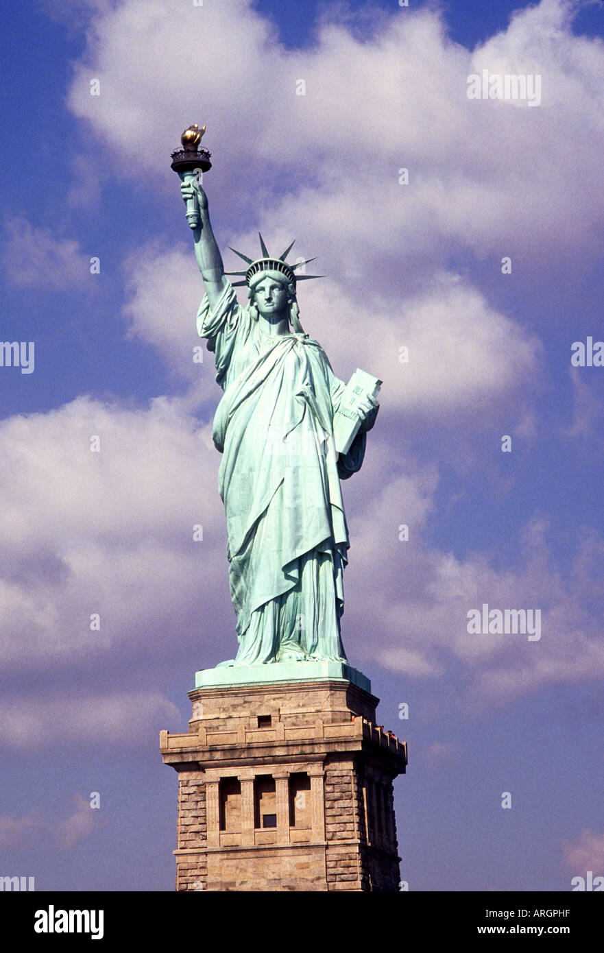 The Statue of Liberty holding her torch aloft outlined against the sky
