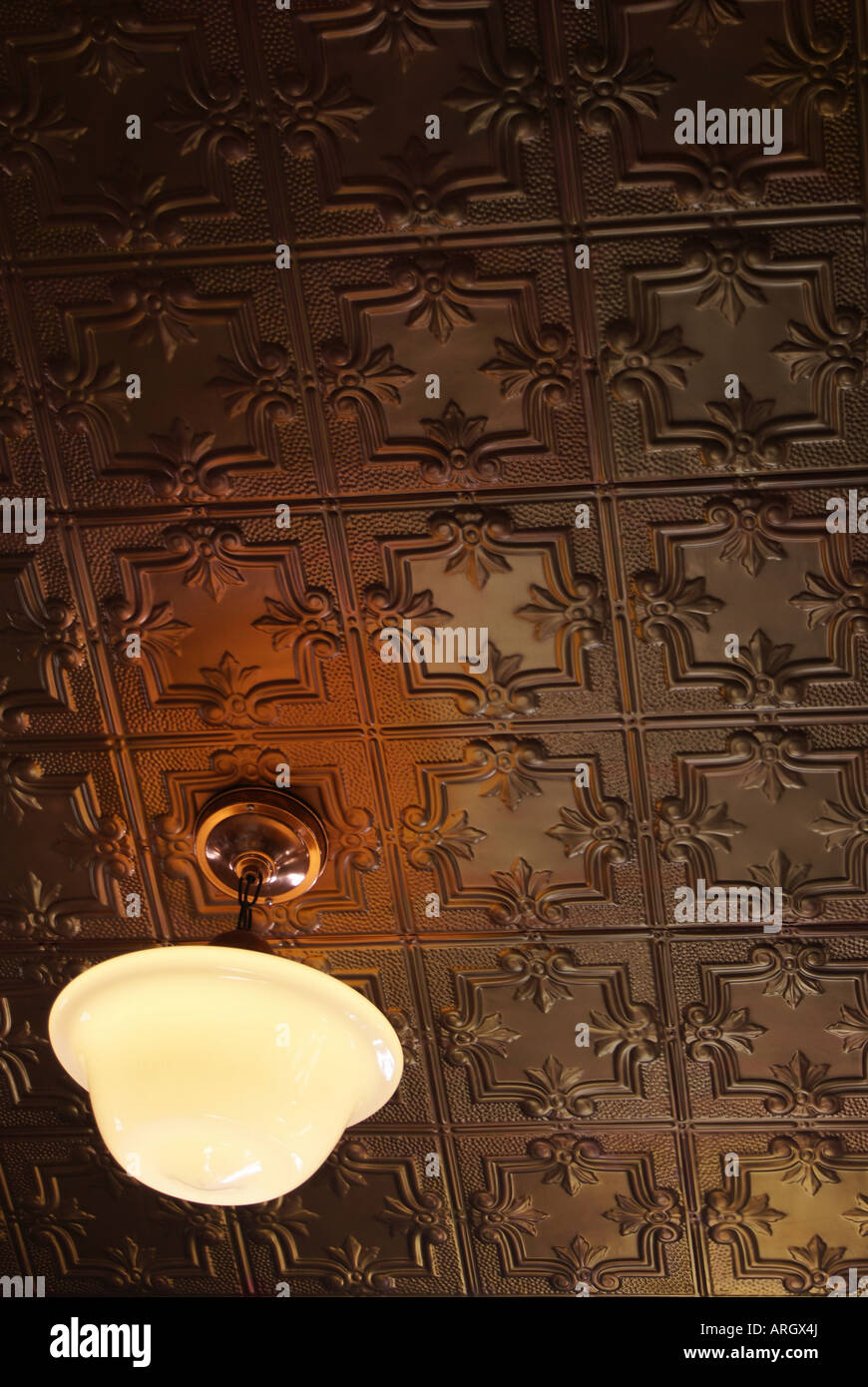 Close Up Of A Ceiling Lamp Suspended From An Antique Tin Ceiling