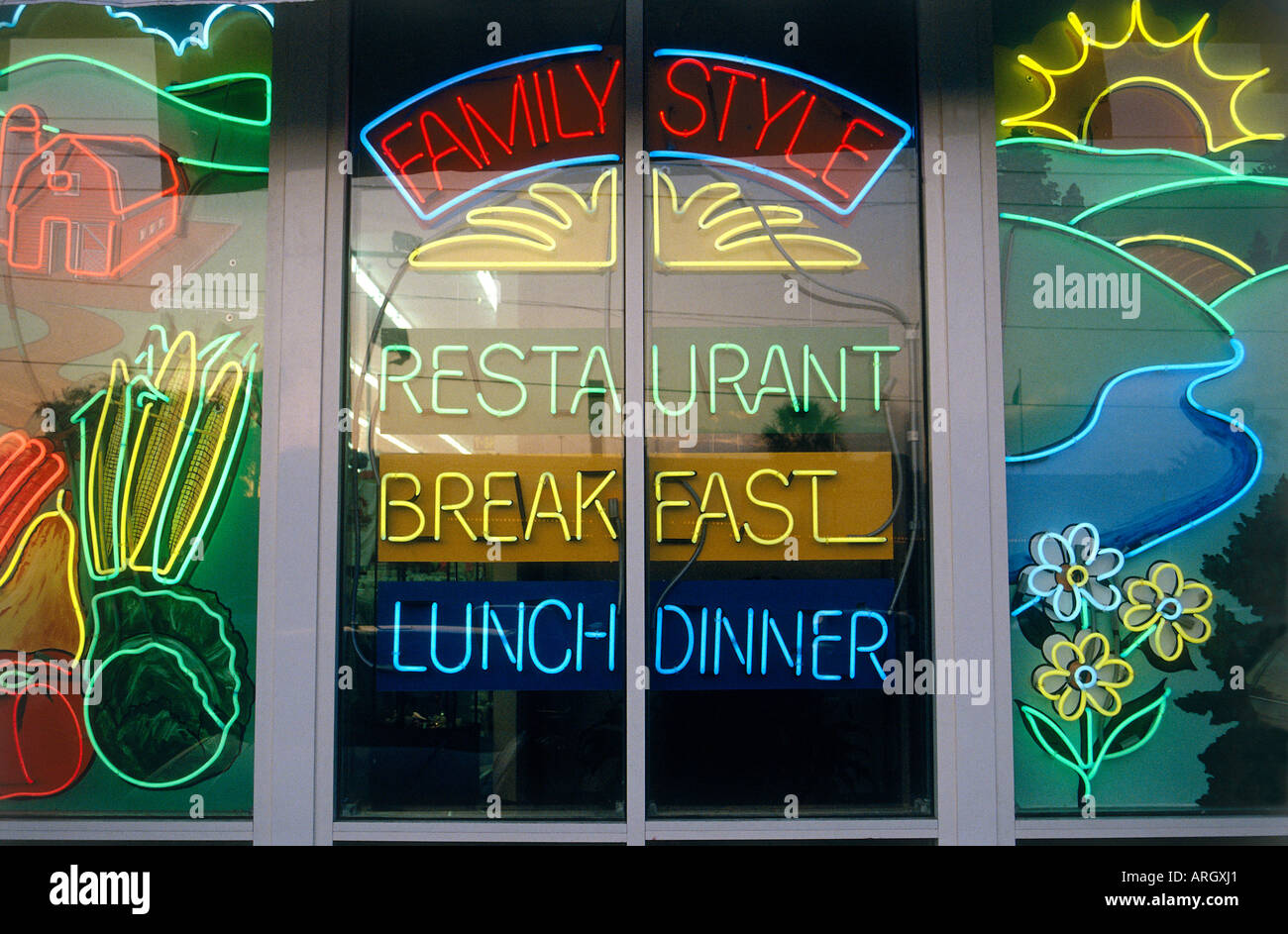 Neon lights in various colours and patterns advertise a family restaurant that offers lunch dinner and even breakfast on International Drive Stock Photo