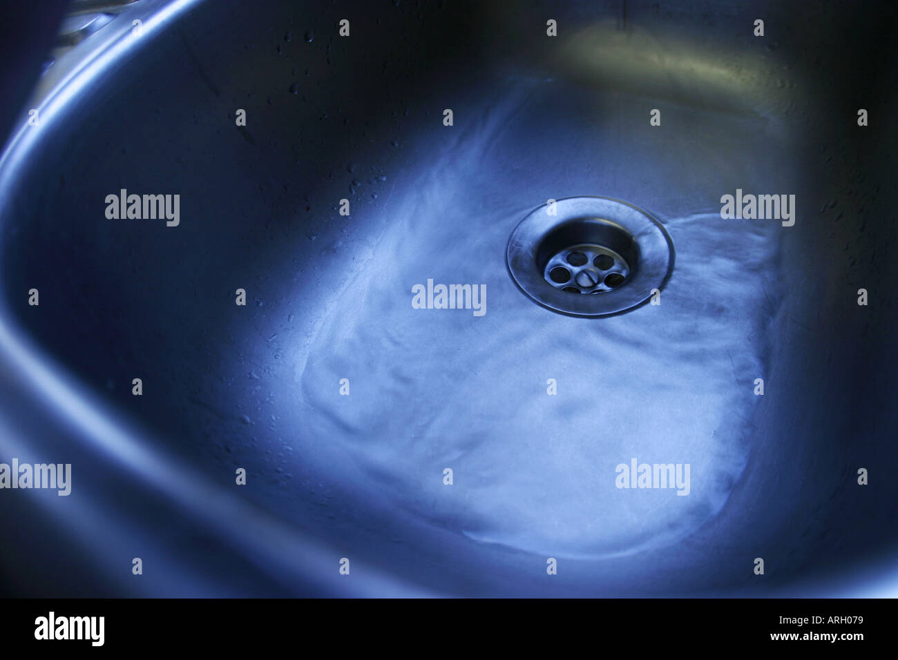 water draining down sink plug hole Stock Photo Alamy