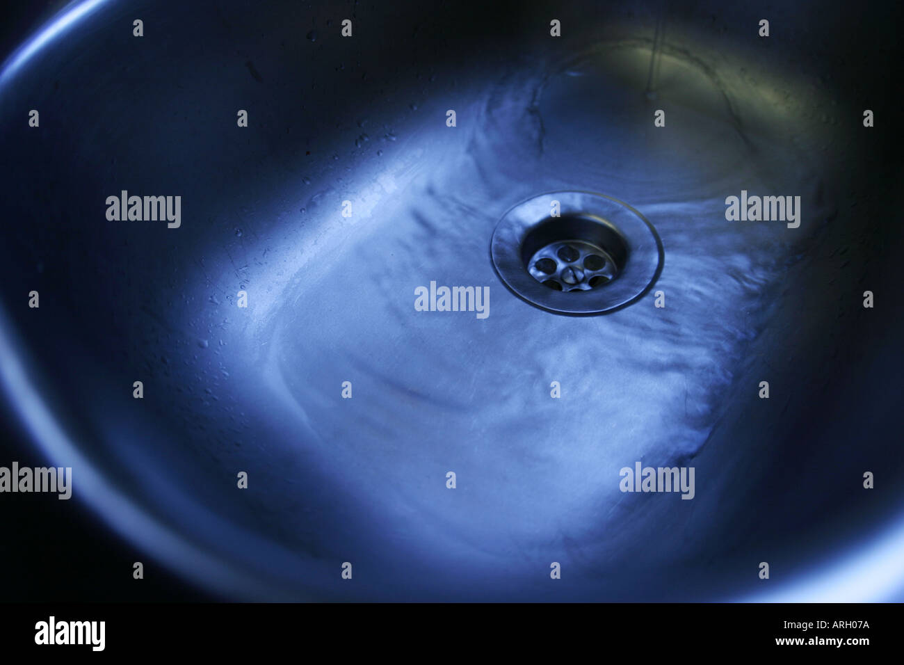 water draining down sink plug hole Stock Photo Alamy