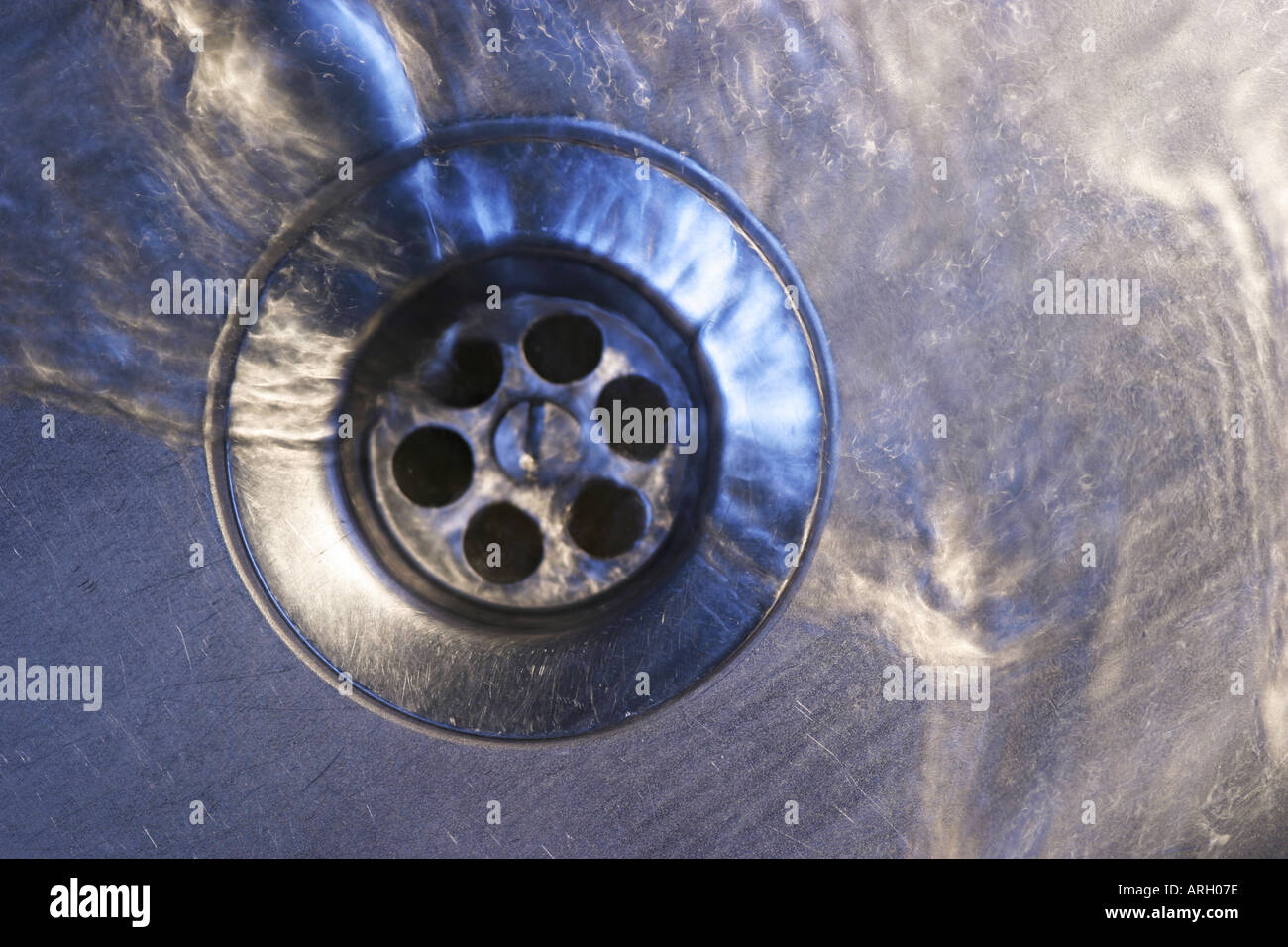 water draining down sink plug hole Stock Photo