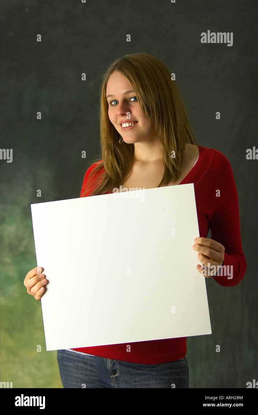 Cute young caucasian woman with long hair holding a blank white sign ...