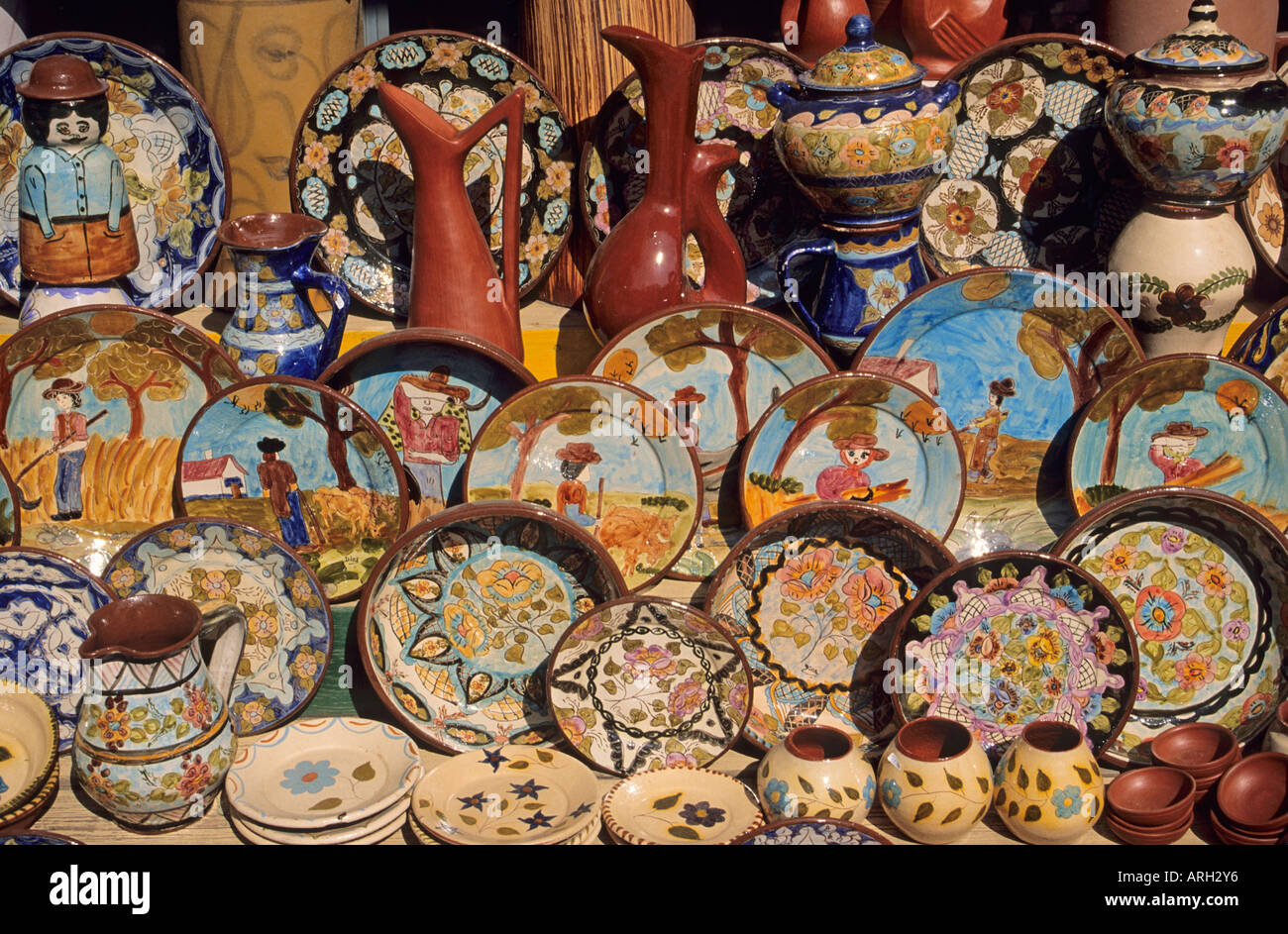 A colourful collection of Portuguese ceramics decorated with traditional designs and patterns in muted colours for sale in a gift shop in the sun drenched Algarve Stock Photo