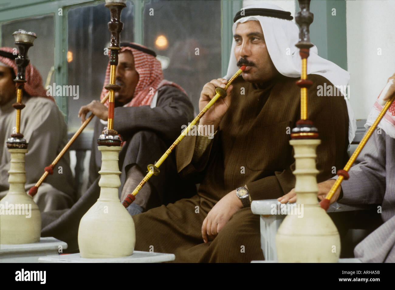 Men smoking hookahs in a cafe in Kuwait Stock Photo