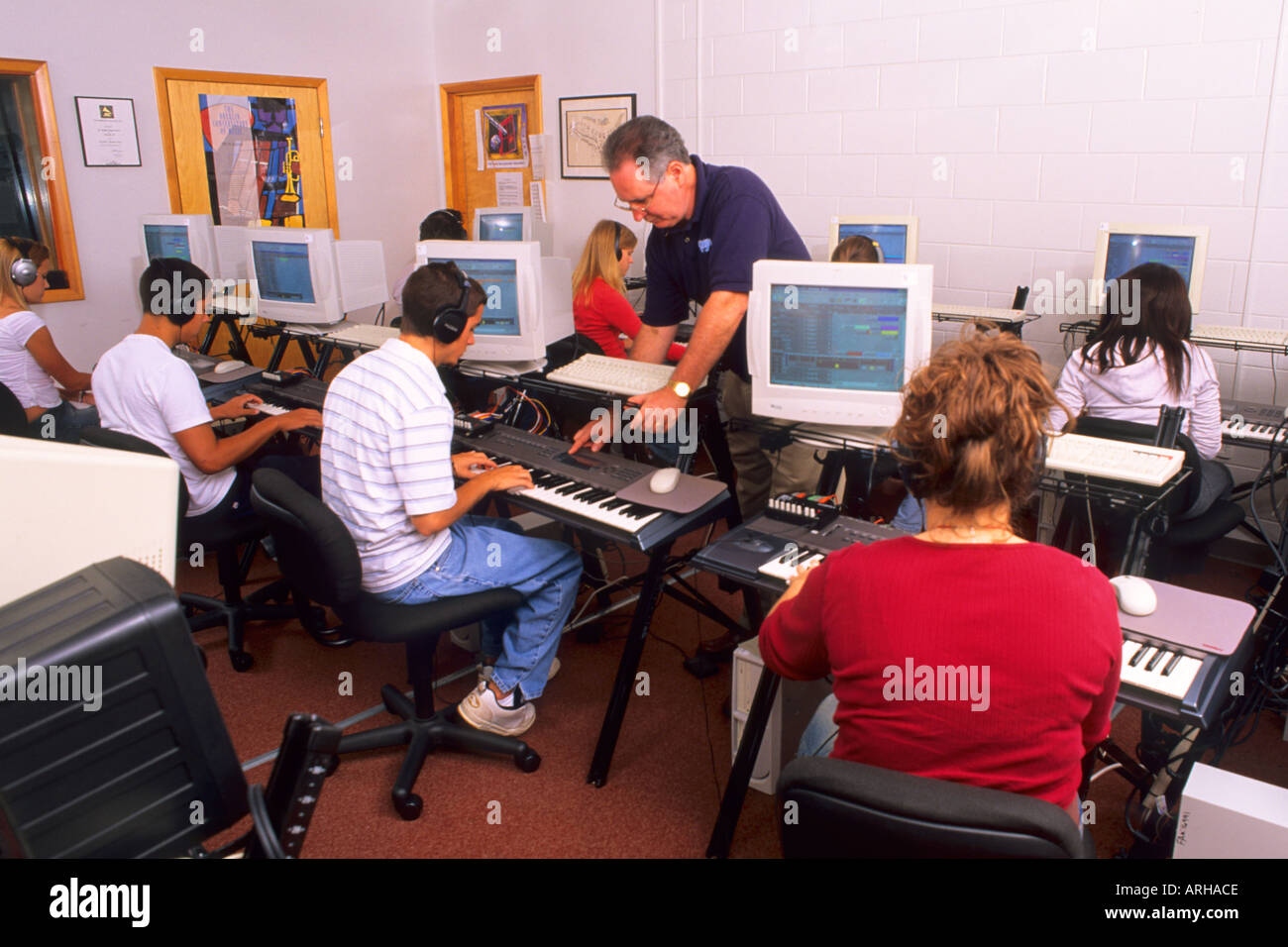 Students Learning Electronic Keyboard from Music Teacher Stock Photo