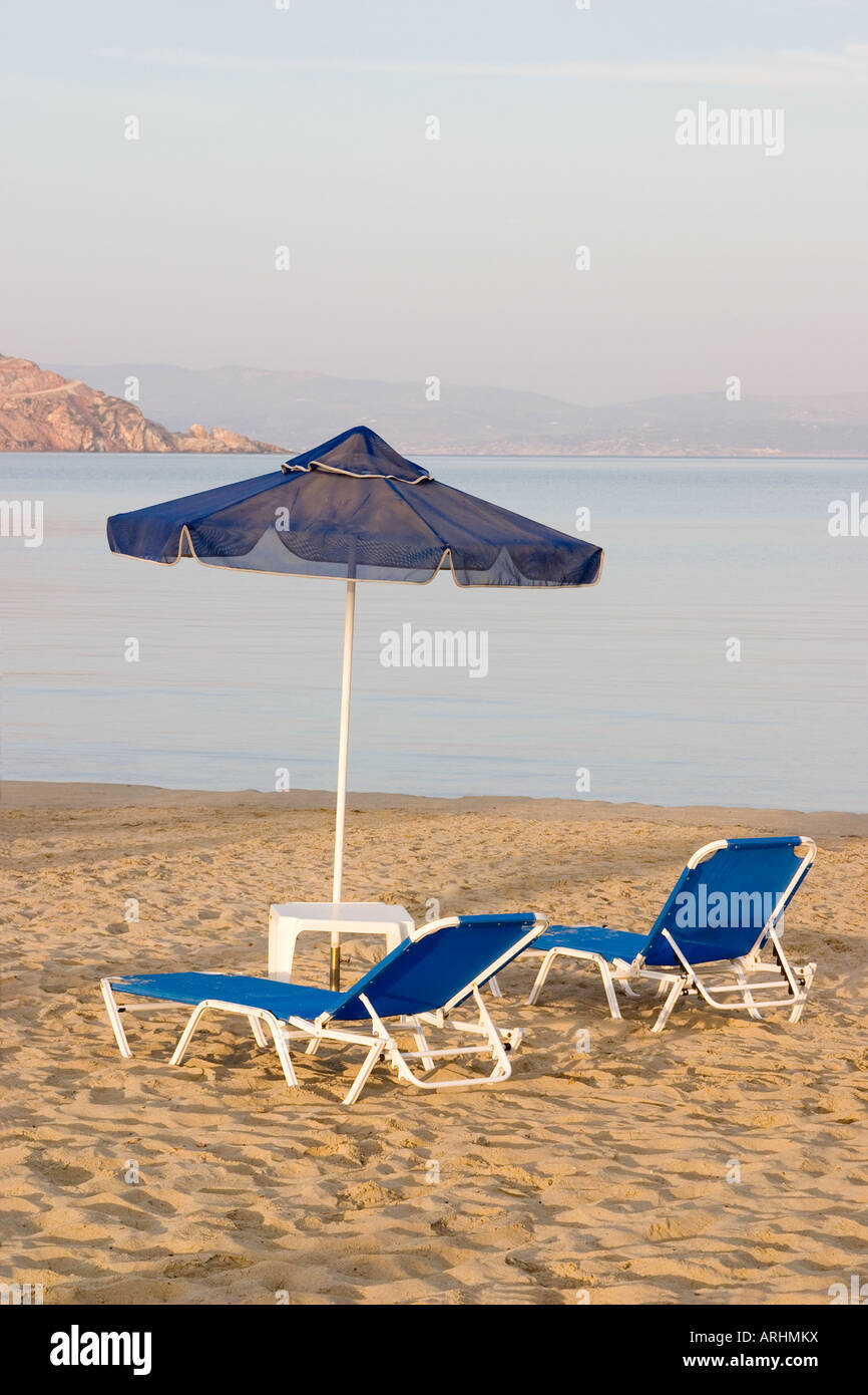 Umbrella and two chaise lounge chairs on beach Stock Photo - Alamy