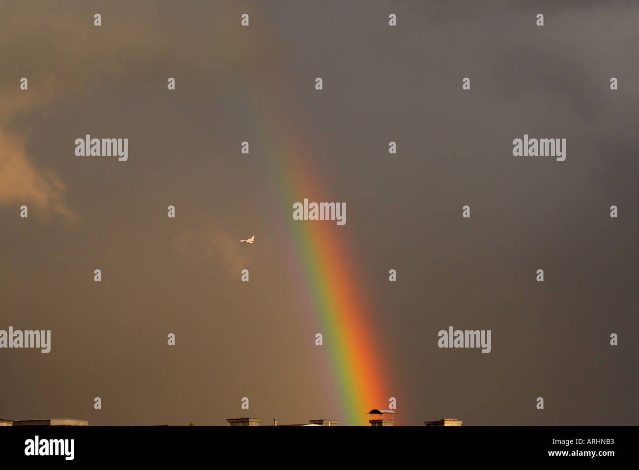 Rainbow and a plane in the sky Stock Photo - Alamy