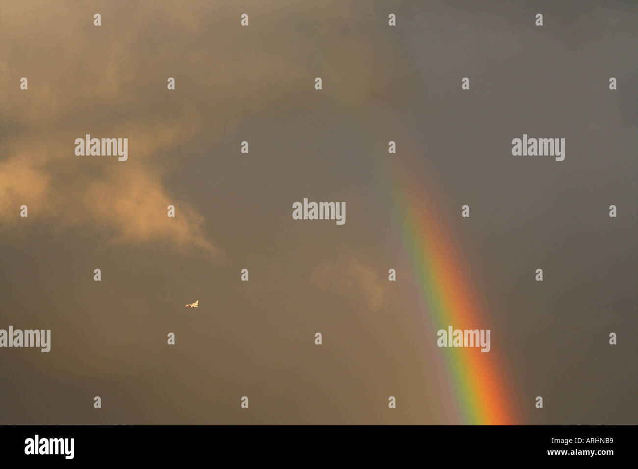 Rainbow and a plane in the sky Stock Photo - Alamy