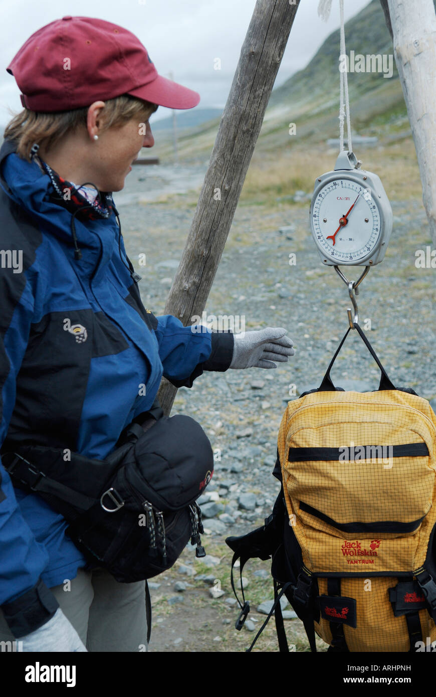 Middle aged woman weighing her backpack at Sylarna mountain station Storulvaan Jamtland Sweden August 2007 Stock Photo
