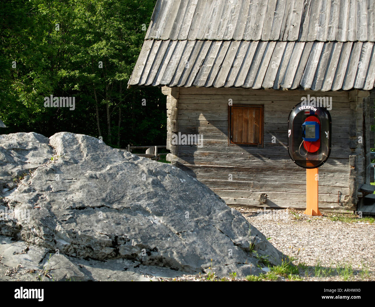 modern telephone pillar in front of an old woodshed in Slovenia at the beginning of the valley Logarska Dolina in the Alps Stock Photo