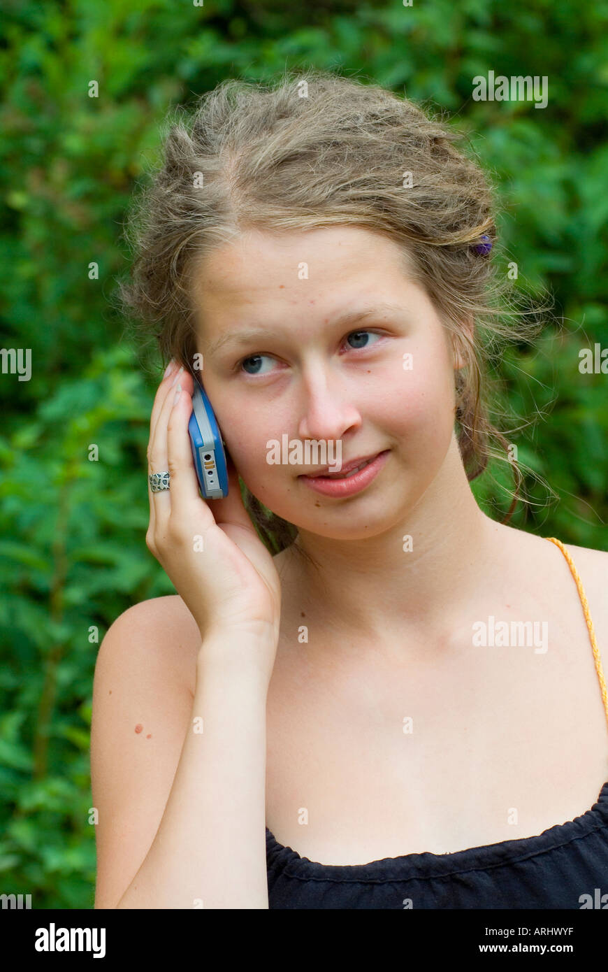 young woman girl making a phone call calling with a mobile phone facial expression is sceptical Stock Photo