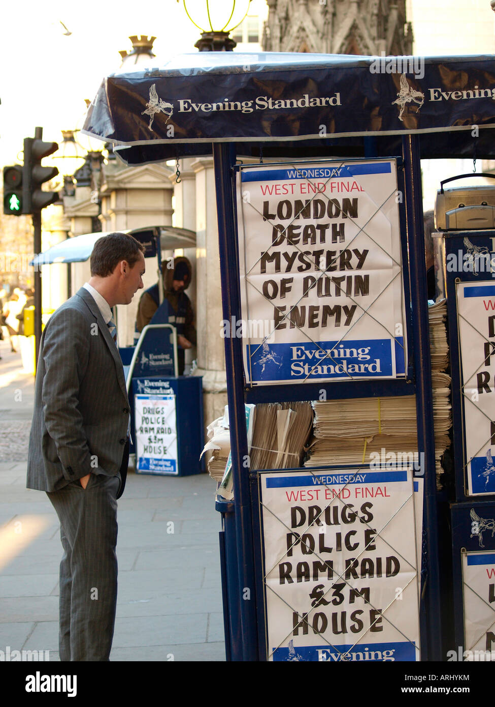 A customer discuses the news with a paper vendor at his stall. The Strand, London England Stock Photo
