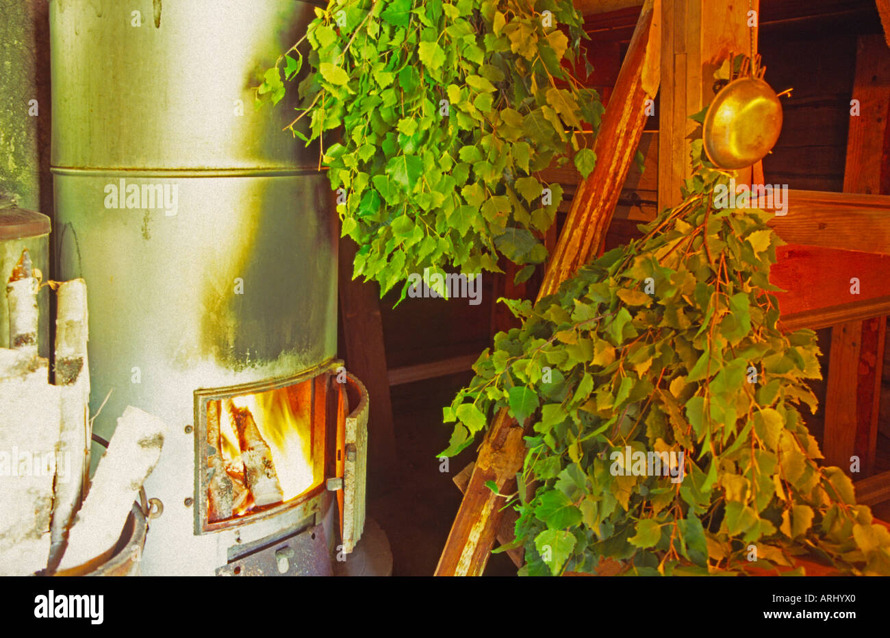 old sauna oven with fire two tufts of branches of birch in a sauna in