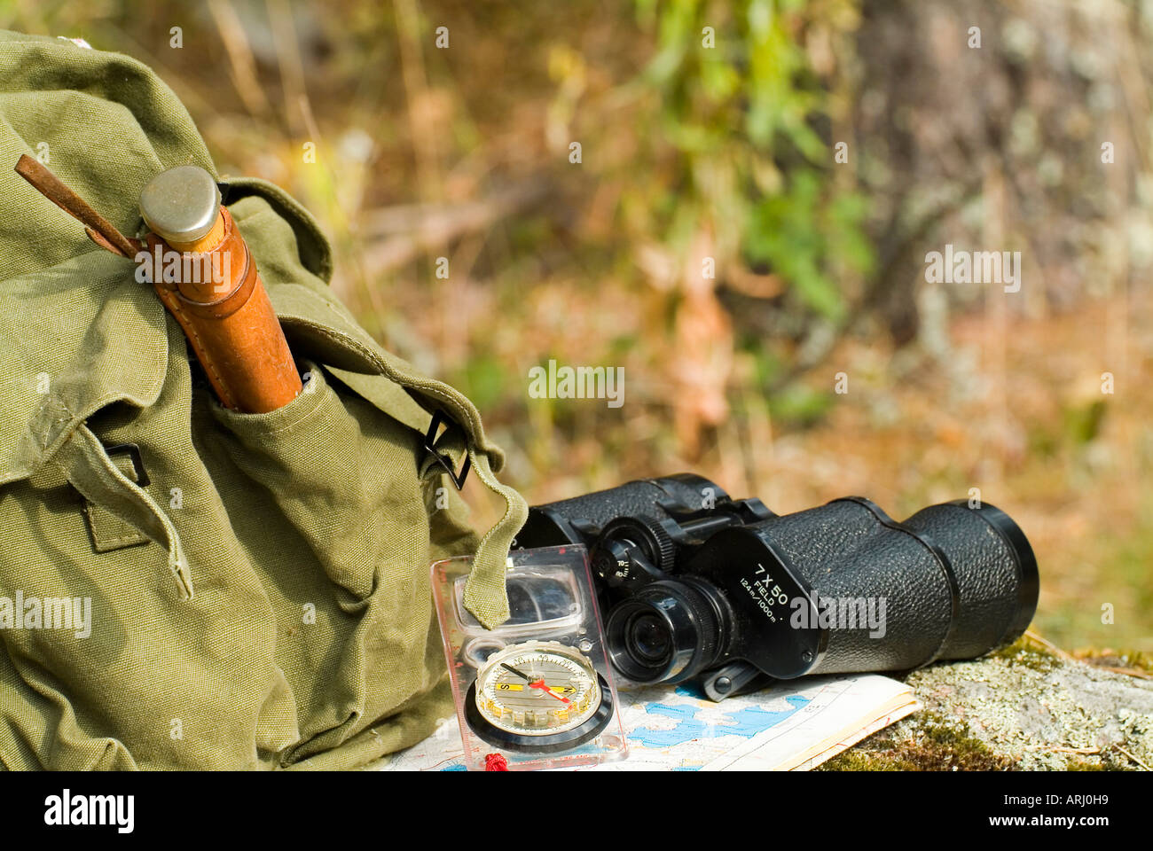 equipment for an expedition in the nature old rucksack backpack knife compass with a map a pair of binoculars Stock Photo