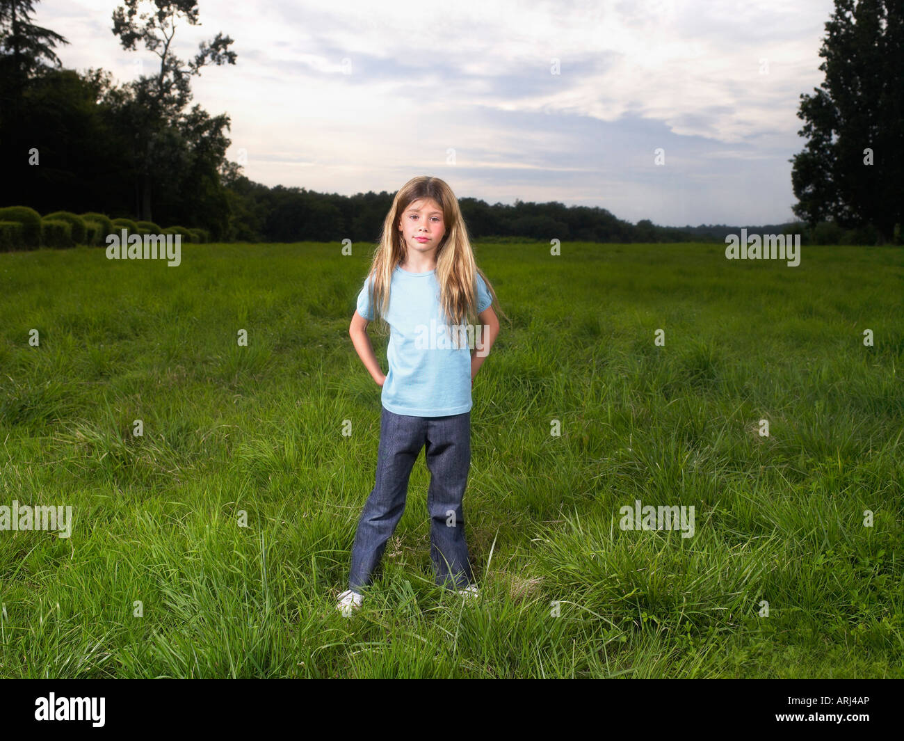 Young girl standing in a field Stock Photo - Alamy