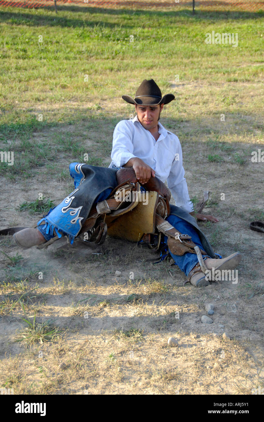 Cowboy practices holding onto his saddle prior to a bronco riding event at a Rodeo Stock Photo