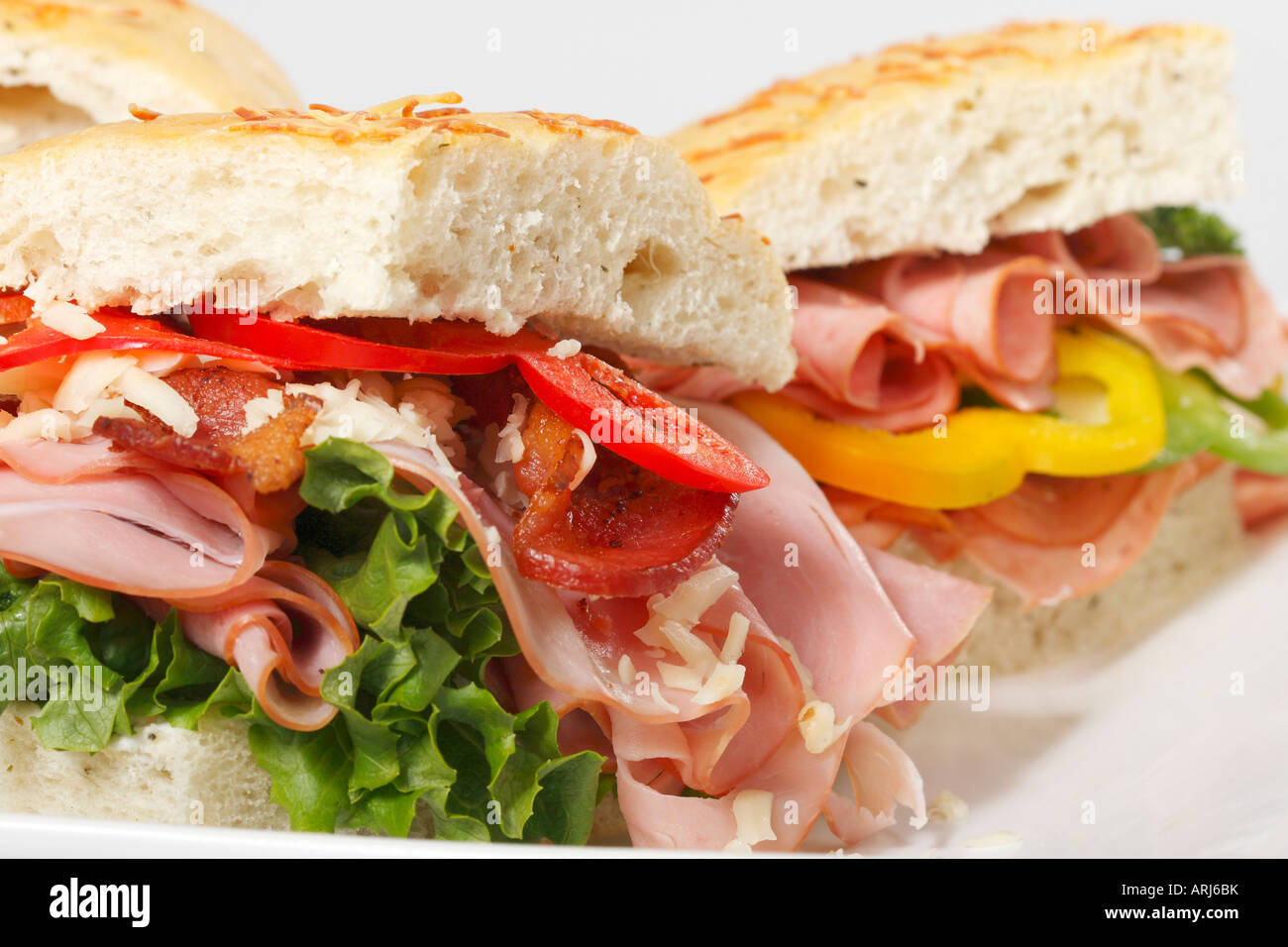 Cross section of Focaccia sandwiches with ham lettuce cheese on platter ...